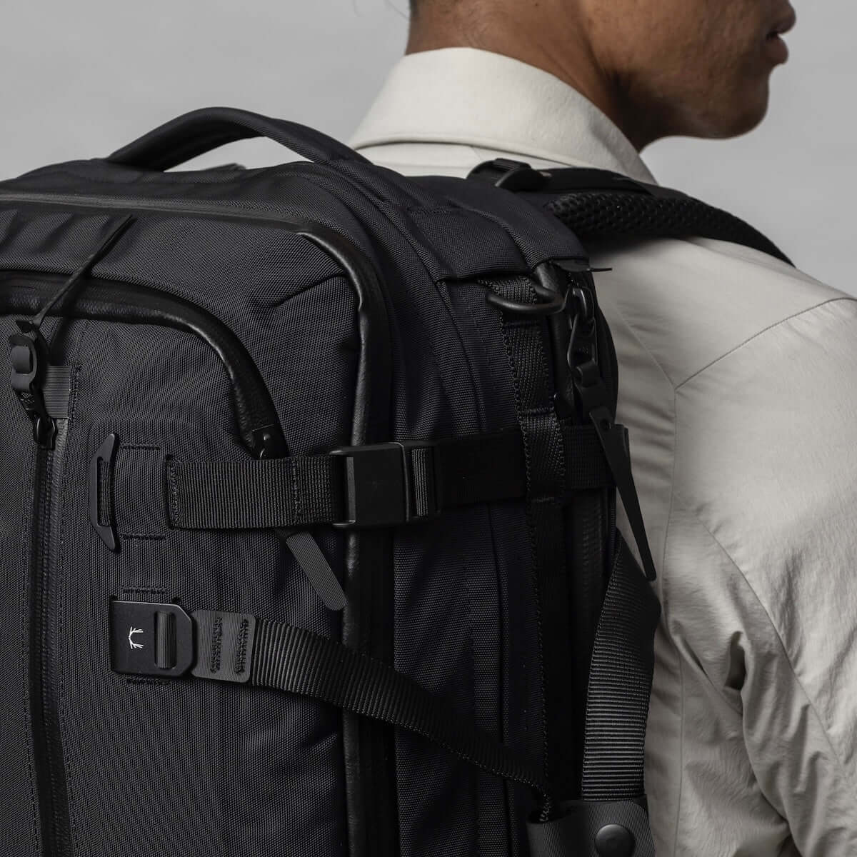 Close-up of a person wearing the Black Ember FORGE 40L travel backpack from the side.