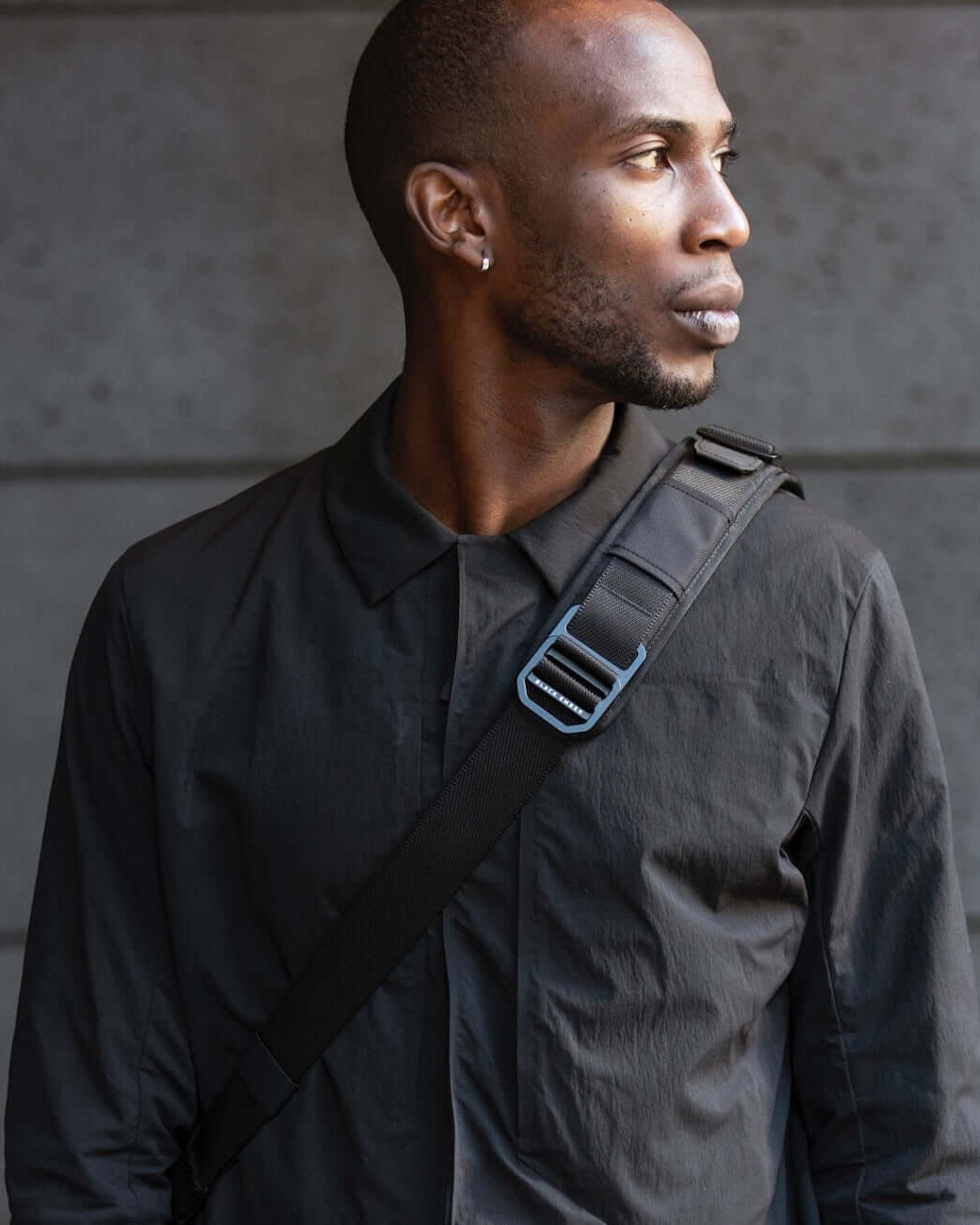 Man wearing the Black Ember FORGE SB 20L Minimalist Soft Brief as a crossbody backpack, showcasing its sleek shoulder strap design for EDC use.