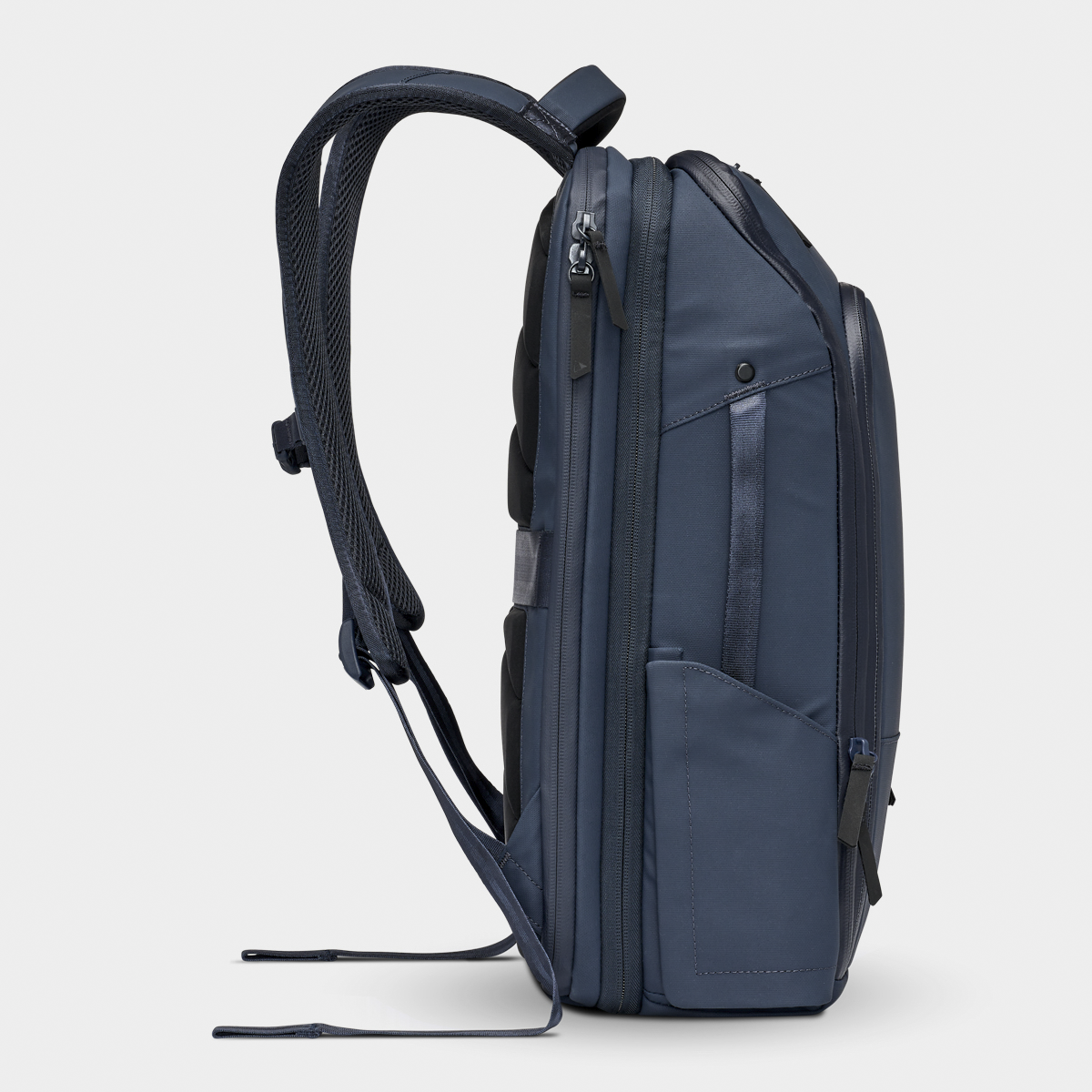 Nomatic Travel Pack side view in navy blue, showing expandable design, weather-resistant fabric, and organized compartments for tech gear.