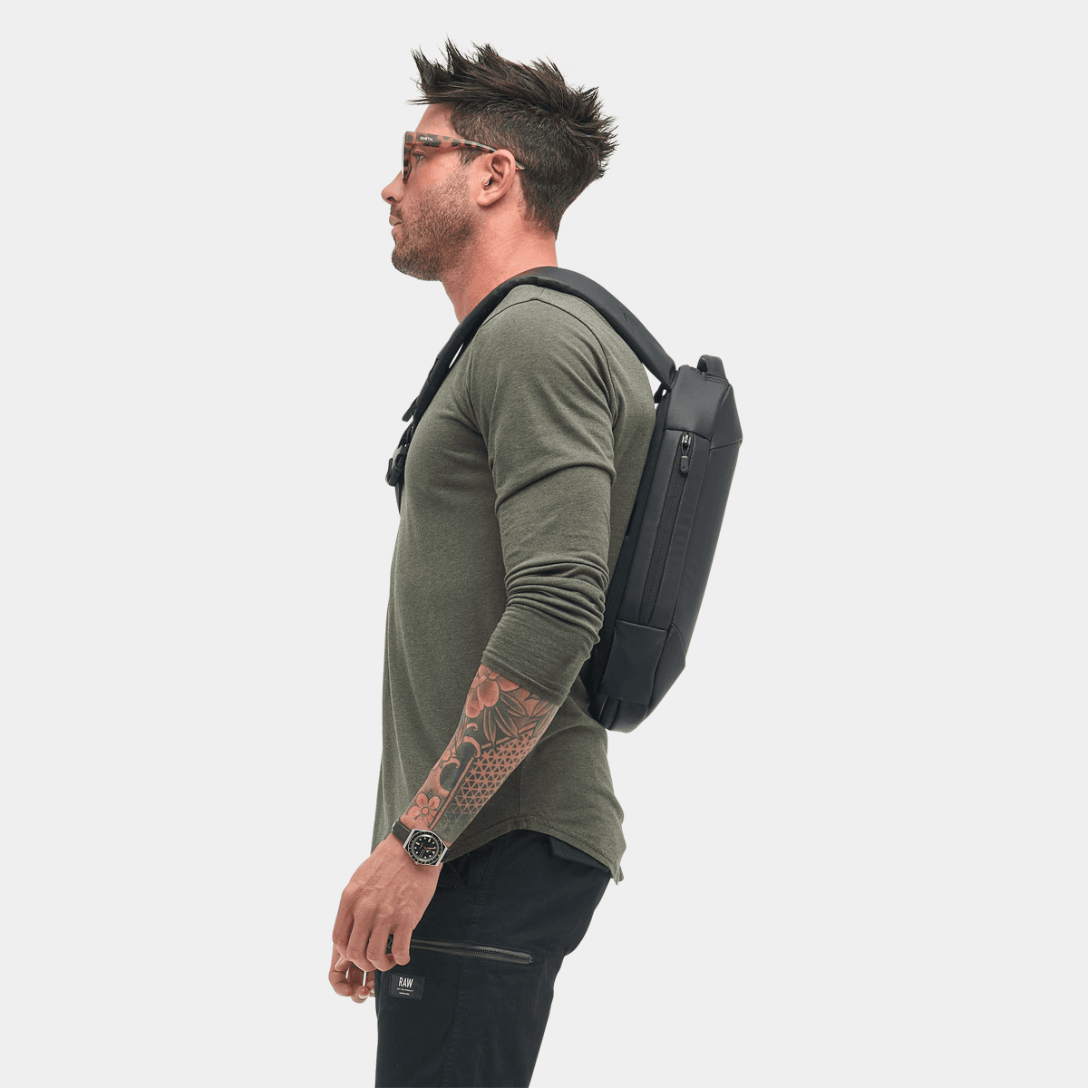 Man wearing the Nomatic Navigator RS Sling 10L in a side profile, showcasing its sleek design and functionality.