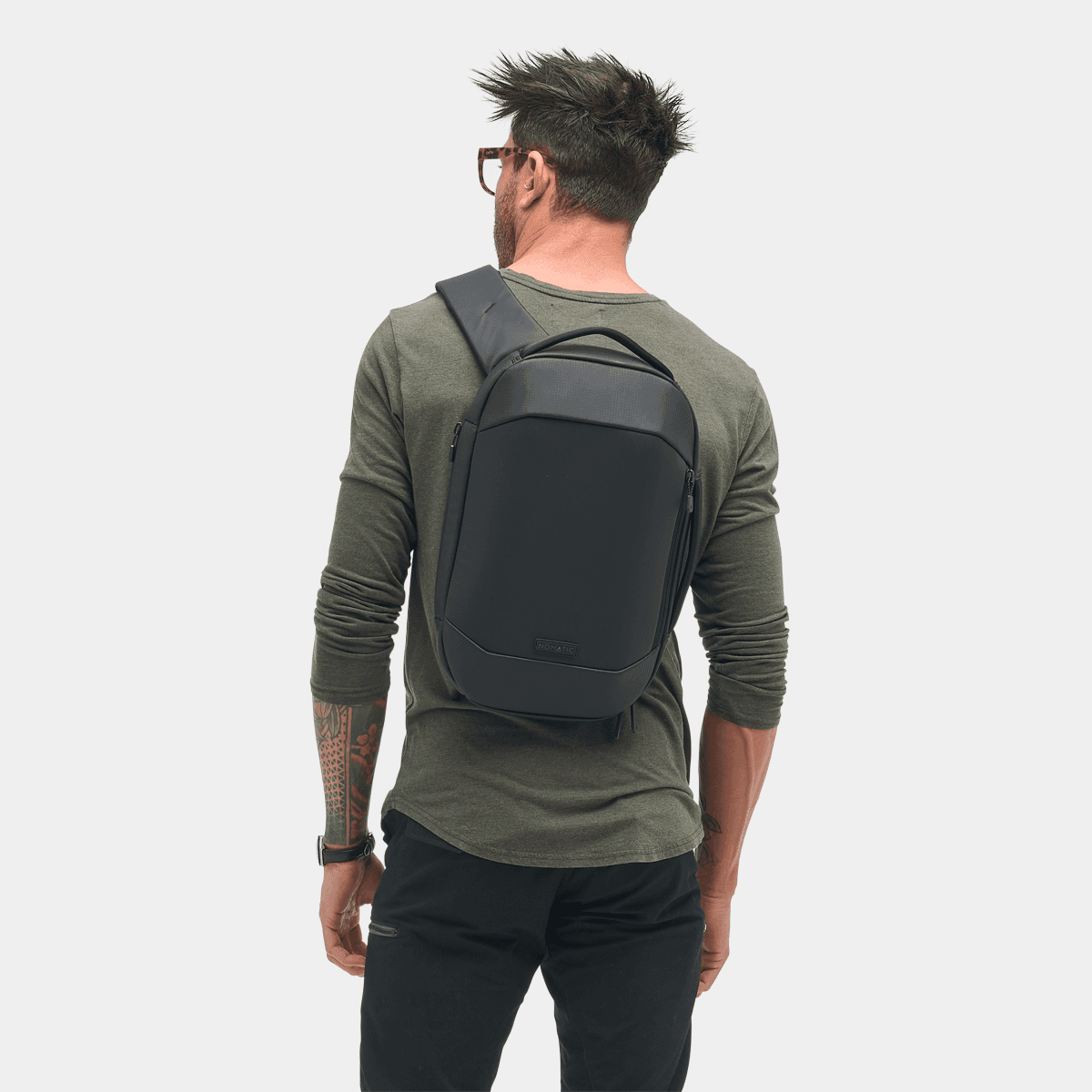 Man wearing the Nomatic Navigator RS Sling 10L, showcasing its sleek and functional design from the back.
